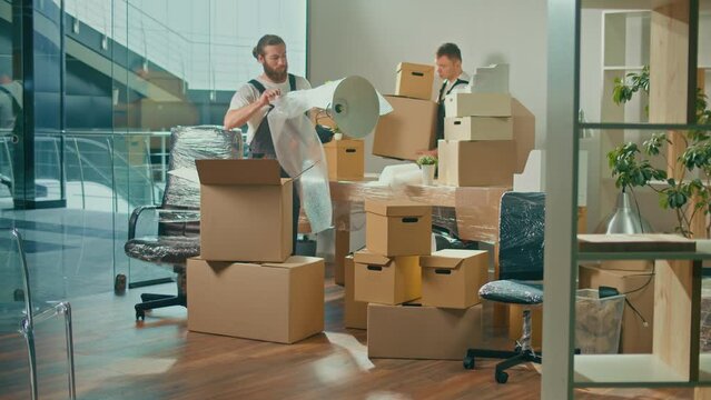 Workers of Moving Company With Uniforms Carefully Packing and Carrying Boxes. Team of Employee Workers Helps Customers to Relocation. Shipping and Packaging Business Occupation Service Company.