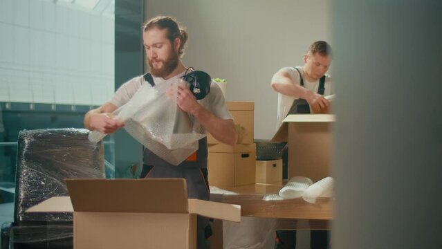 Workers of Moving Company With Uniforms Carefully Packing and Carrying Boxes. Team of Employee Workers Helps Customers to Relocation. Shipping and Packaging Business Occupation Service Company.