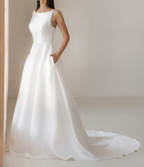 Side view of beautiful brunet bride in long white wedding dress. Gorgeous sleeveless wedding dress