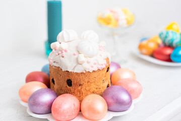 Painted Easter eggs with decorated Easter cake on white background close up with selective focus. Happy Easter concept