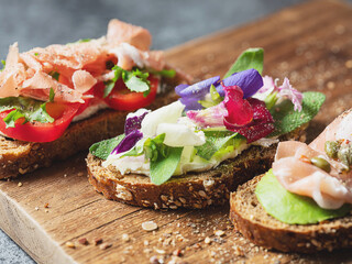 Variety of mini sandwiches with cream cheese, vegetables and salami