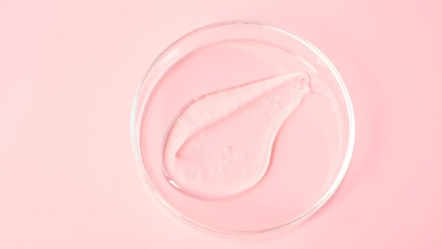 Smear of shower gel or shampoo on pink background close-up top view.