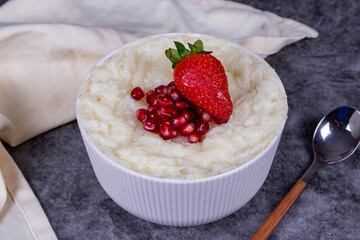 Gullac dessert. Traditional Ramadan dessert. Pomegranate and strawberry gullac dessert in bowl