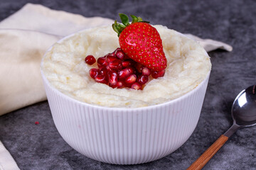 Gullac dessert. Traditional Ramadan dessert. Pomegranate and strawberry gullac dessert in bowl