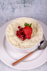 Gullac dessert. Traditional Ramadan dessert. Pomegranate and strawberry gullac dessert in bowl