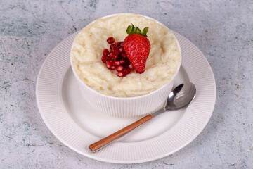 Gullac dessert. Traditional Ramadan dessert. Pomegranate and strawberry gullac dessert in bowl