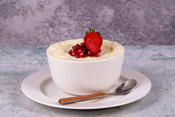 Gullac dessert. Traditional Ramadan dessert. Pomegranate and strawberry gullac dessert in bowl