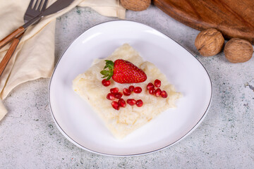 Gullac dessert. Traditional Ramadan dessert. Gullac dessert with pomegranate and strawberry on the plate