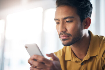 Serious asian man, phone and social media for communication or networking at home. Focused male freelancer face on mobile smartphone app for chatting, texting or browsing on internet or research