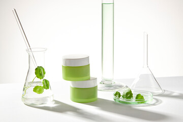 Empty label jars and an erlenmeyer flask with a glass rod and gotu kola leaves. Laboratory concept...