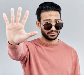 Stop, portrait and a cool man with sunglasses isolated on a white background in a studio. No,...