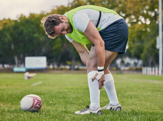 Rugby, pain and man with legs injury on sports field after practice match, training and game outdoors. Medical emergency, accident and male athlete with joint inflammation, knee sprain and tendinitis
