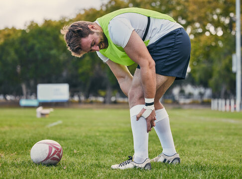Rugby, pain and man with legs injury on sports field after practice match, training and game outdoors. Medical emergency, accident and male athlete with joint inflammation, knee sprain and tendinitis