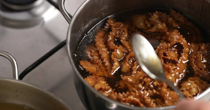 Witness the chebakia dance in honey, as each piece is submerged, absorbing the sweet nectar to achieve its delectable, glossy exterior.