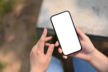 Top view of a woman using her phone in the park or garden. phone white screen mockup