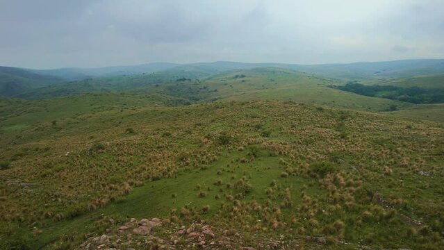 Drone backtracking over the top of a small mountain in a field. Ceballos River. C&oacute;rdoba. Argentina.