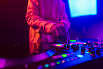 Fototapeta na wymiar Hands of a DJ creating and regulating music on dj console mixer at club concert