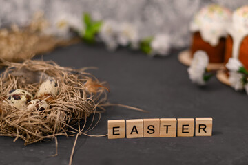 Easter text on wooden tablets. Quail eggs in the nest.