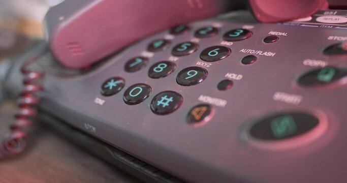 Old facsimile button phone, handset removed. Red-blue flashing light. Concept of emergency, emergency services, no one answering. Close-up.