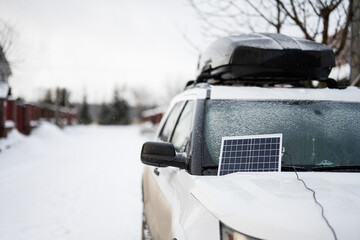 Portable solar panel on SUV car at winter.