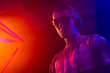Club DJ playing music at party wearing sunglasses