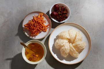 Flat lay of bird’s nest soup, jujube inside a bowl, a dish of edible bird’s nest and cordyceps. Bird's nest and herbs are well-known in Korea and China as a traditional medicine