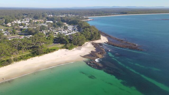 Aerial drone view of Huskisson in the City of Shoalhaven on the shores of Jervis Bay, NSW, Australia, traveling along Huskisson Beach on a bright sunny morning    