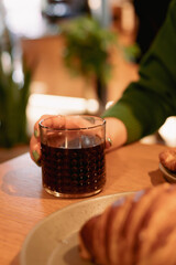 Fototapeta na wymiar Coffee in a glass held by a female hand