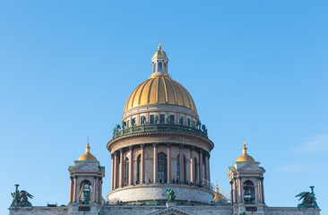 Fototapeta premium The golden dome of St. Isaac's Cathedral in St. Petersburg against the blue sky.