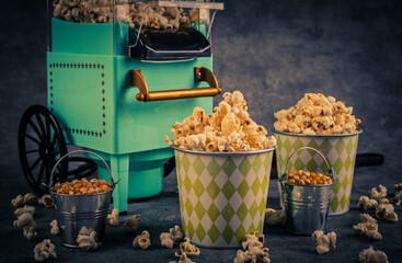 Popcorn machine and glass of beer on gray background. Toned.