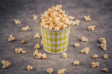 Popcorn in a paper cup on a blue background. Toned.