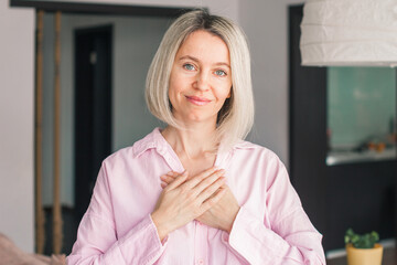 happy adult female volunteer holding folded hands on chest