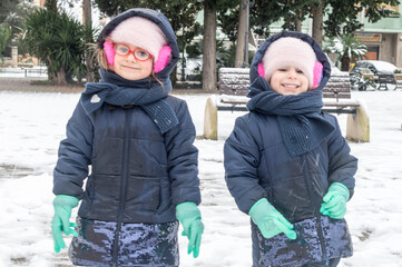 Ritratto di due sorelle gemelle d'inverno sulla neve.