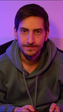 Exicted male cybersport gamer playing game with controller. Vertical video