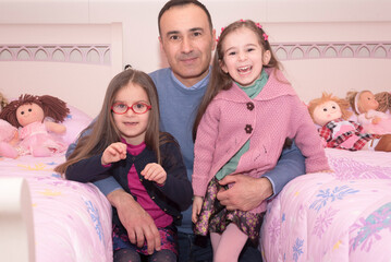 Ritratto di un padre con le figlie gemelle di 5 anni.