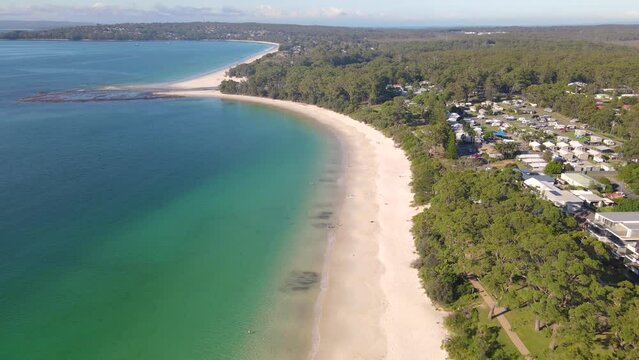 Aerial drone view of Huskisson in the City of Shoalhaven on the shores of Jervis Bay, NSW, Australia, traveling along Huskisson Beach on a bright sunny morning    