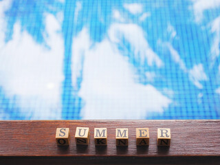 wooden block text Summer on wooden board over swimming pool background