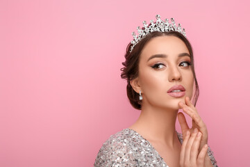 Beautiful young woman wearing luxurious tiara on pink background, space for text © New Africa