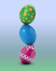 Stack of bright Easter eggs on blue green gradient background