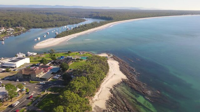 Aerial drone view of Huskisson in the City of Shoalhaven on the shores of Jervis Bay, NSW, Australia, showing Huskisson Sea Pool, Voyager Park and Currambene Creek on a bright sunny morning    