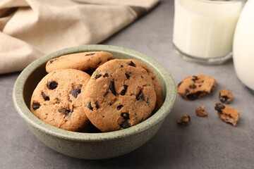Delicious chocolate chip cookies and milk on grey table