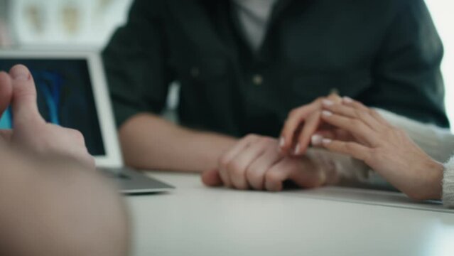 Hands of unrecognizable heterosexual couple supporting each other during discussing medical exam results with a doctor. Shot with RED helium camera in 8K. 