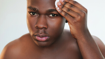 Facial cleansing. Skin care. Grooming hygiene. Closeup of confident man applying refreshing...