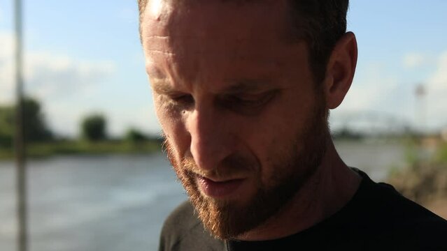 Fingers closeup ticking on wrist watch pedometer of endurance trail run athlete shifting focus on the concentrated face of the sportsman in preparation of outdoor sports exercise training schedule.