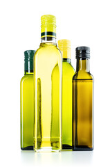 Four full closed glass bottles with olive oil, isolated on a white background. File contains a path to isolation.