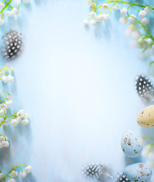 Easter eggs and Spring flower border on blue background; white spring blossom border; copy space