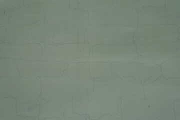 Texture of dark subdued green painted wall with cracks