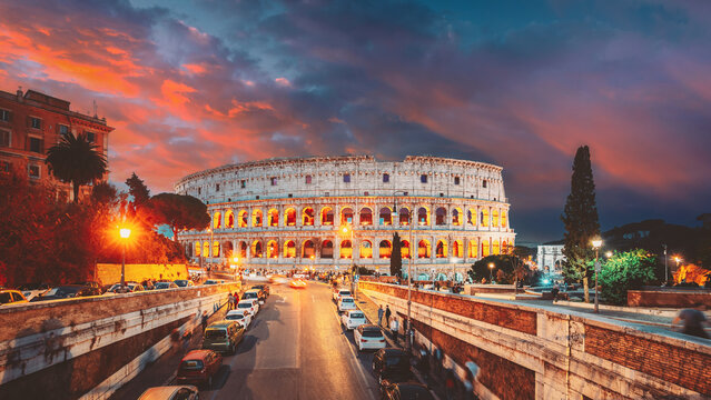 Rome, Italy. Colosseum Also Known As Flavian Amphitheatre In Evening Or Night Time. Amazing Sunset Sky With Saturated Colorful Clouds. Travel Italy.