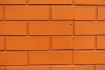 Surface of bright orange brick veneer wall