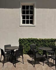 tables on the street in front of the white  window